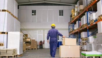 senior-logistic-worker-hardhat-uniform-walking-warehouse-wheeling-palette-jack-back-view-full-length-labor-logistics-concept(1)